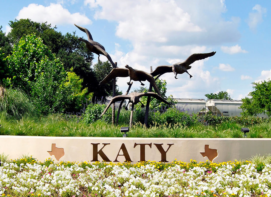 Contact - Closeup View of a Flying Birds Statue in Katy Texas Next to a Field of Wildflowers on a Sunny Day