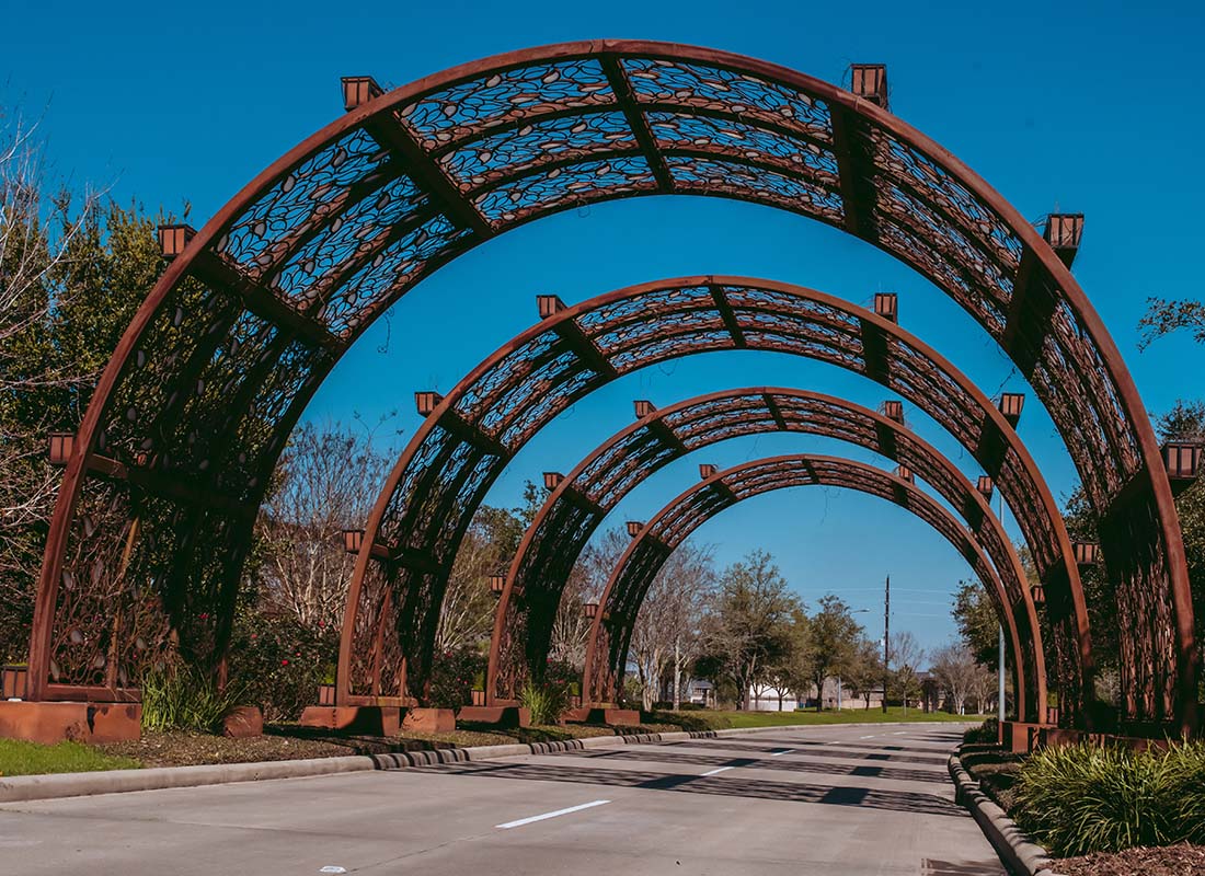 Service Center - Decorative Round Arches Over a Quiet Road in a Residential Community Near Katy Texas on a Beautiful Sunny Day